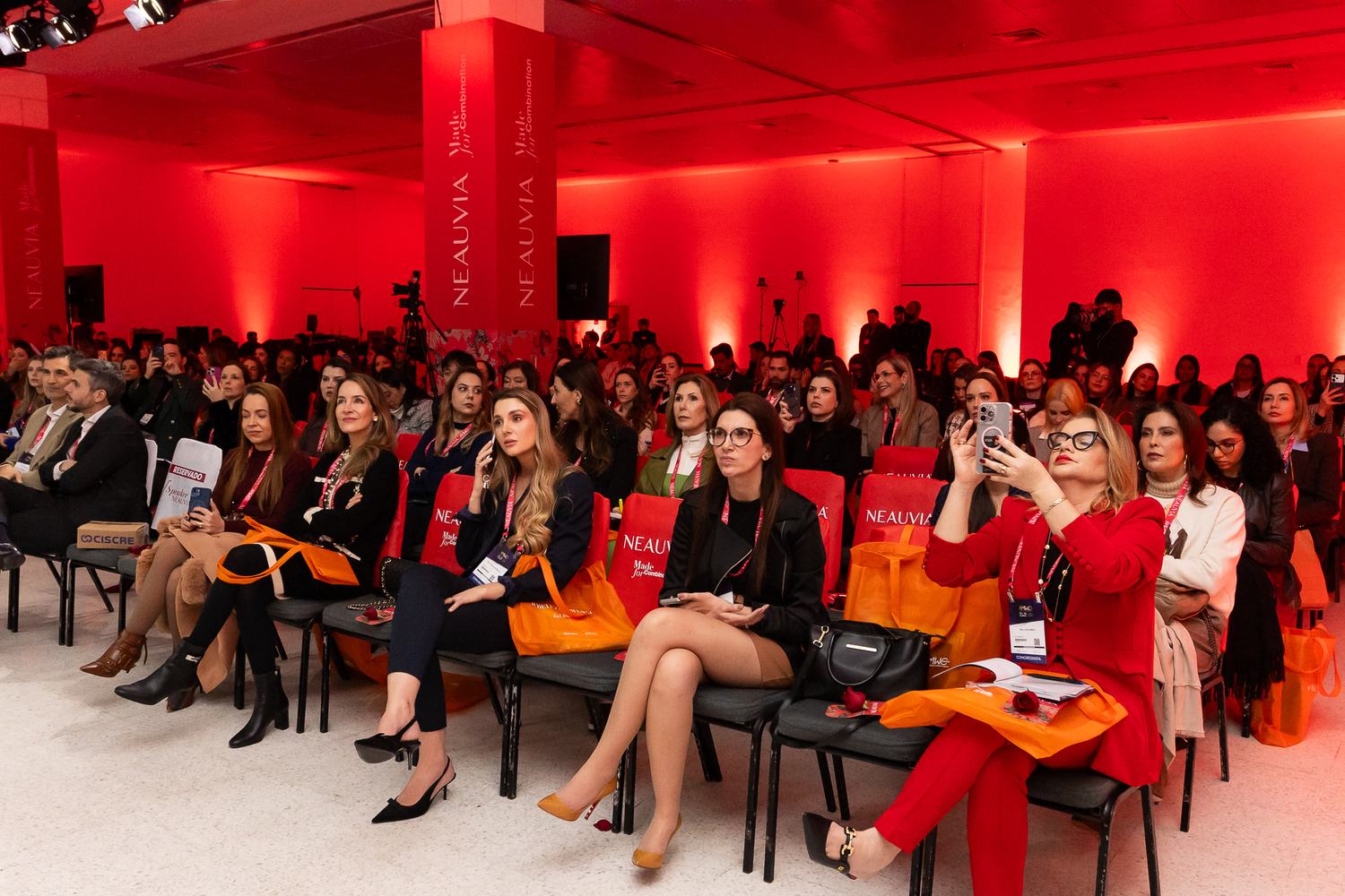 Plateia lotada no auditório iluminado de vermelho